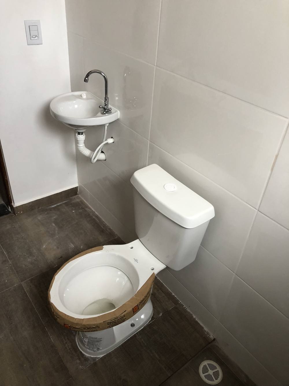 Banheiro com pia e vaso sanitário em casa nova em Cotia